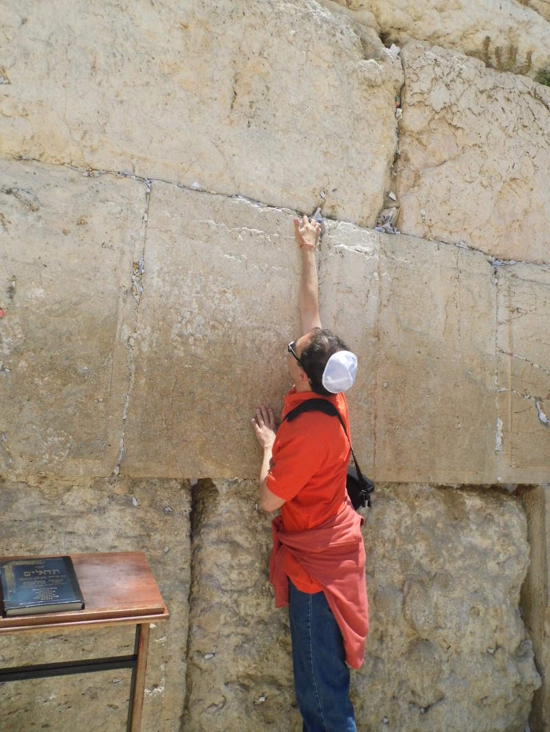 Placing a message to G-d in the cracks of the Western Wall.